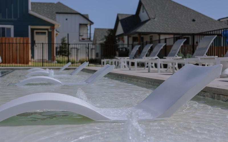 Community pool and deck seating at Chapel Creek Cottages